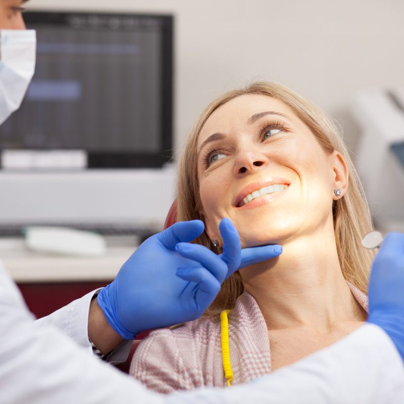 Doctor holding dental client face