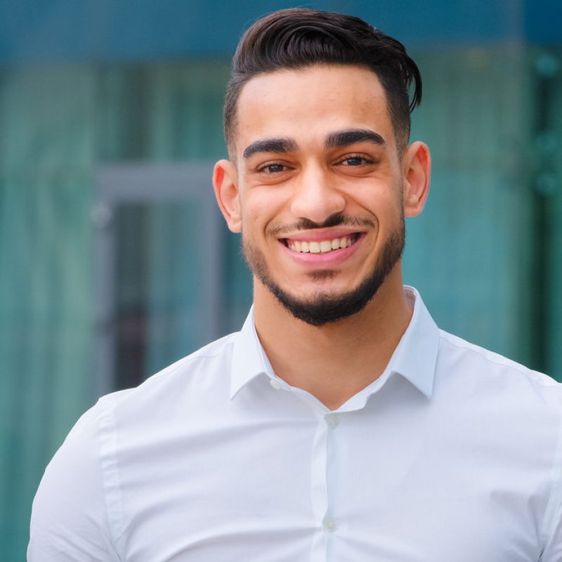 Male portrait happy indian smiling successful adult young man guy bearded businessman boss leader client manager executive entrepreneur wears formal shirt looking at camera smile toothy dental