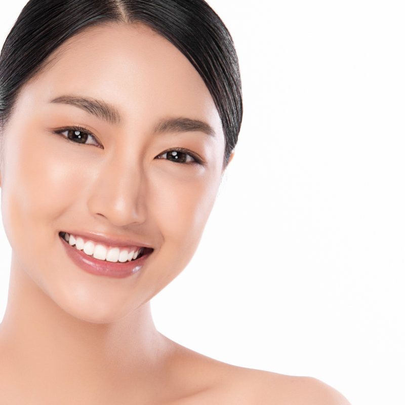 Beautiful smile young woman. White teeth on the master plan. Free space and white background