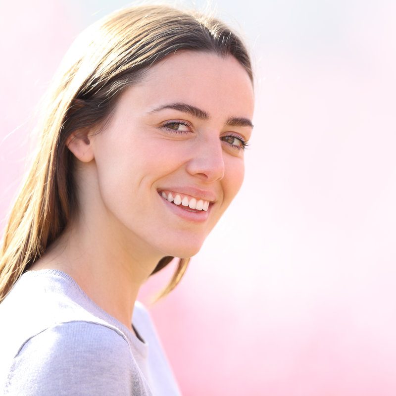 Beautiful woman looking at camera in a pink field