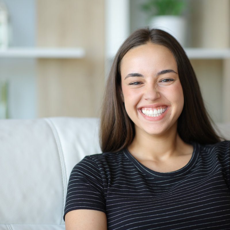 Happy woman with perfect smile looks at camera