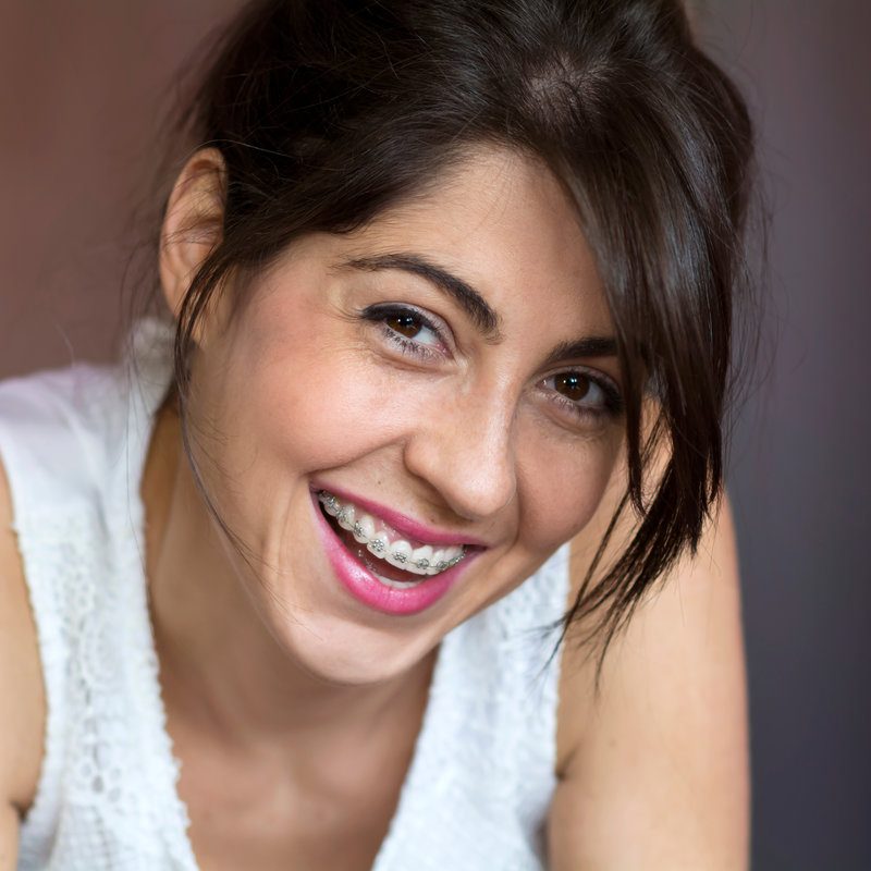 Portrait of a beautiful woman with braces on teeth. Orthodontic treatment. Dental care concept